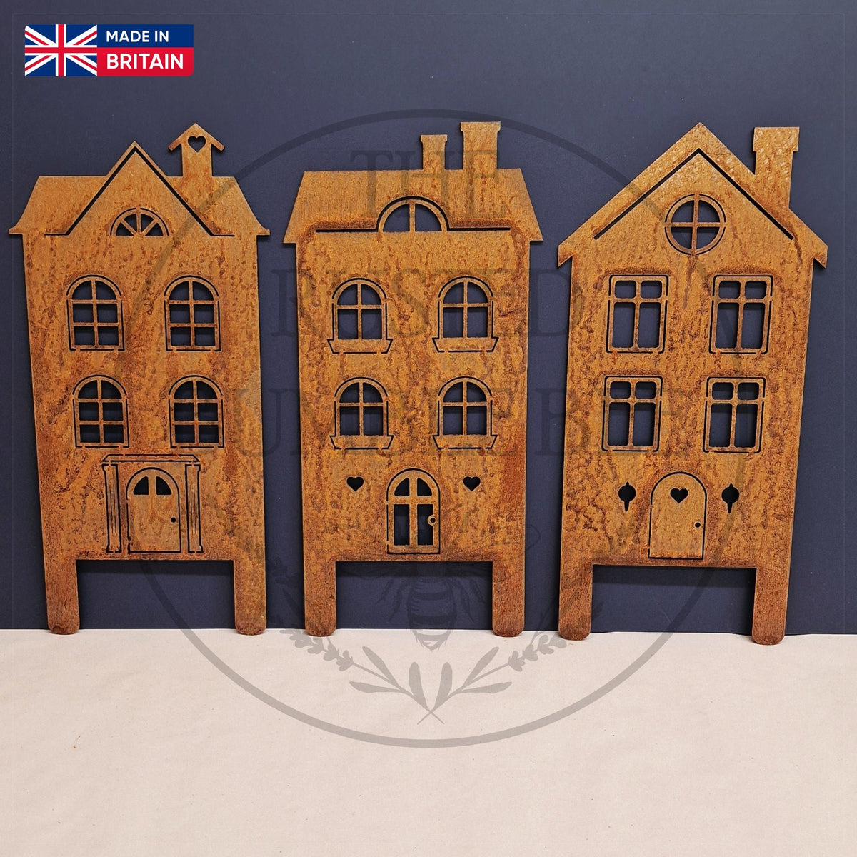 Three meetal house models against a blue background