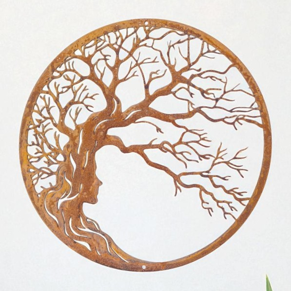 a circular metal sculpture depicting a tree with a woman's face in profile.