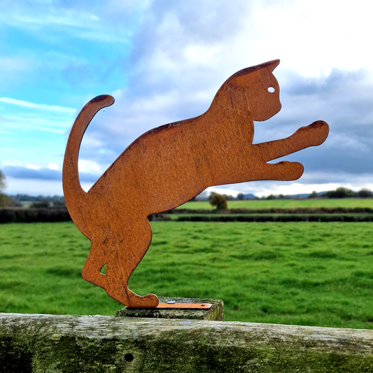 a wooden cutout of a cat on a fence