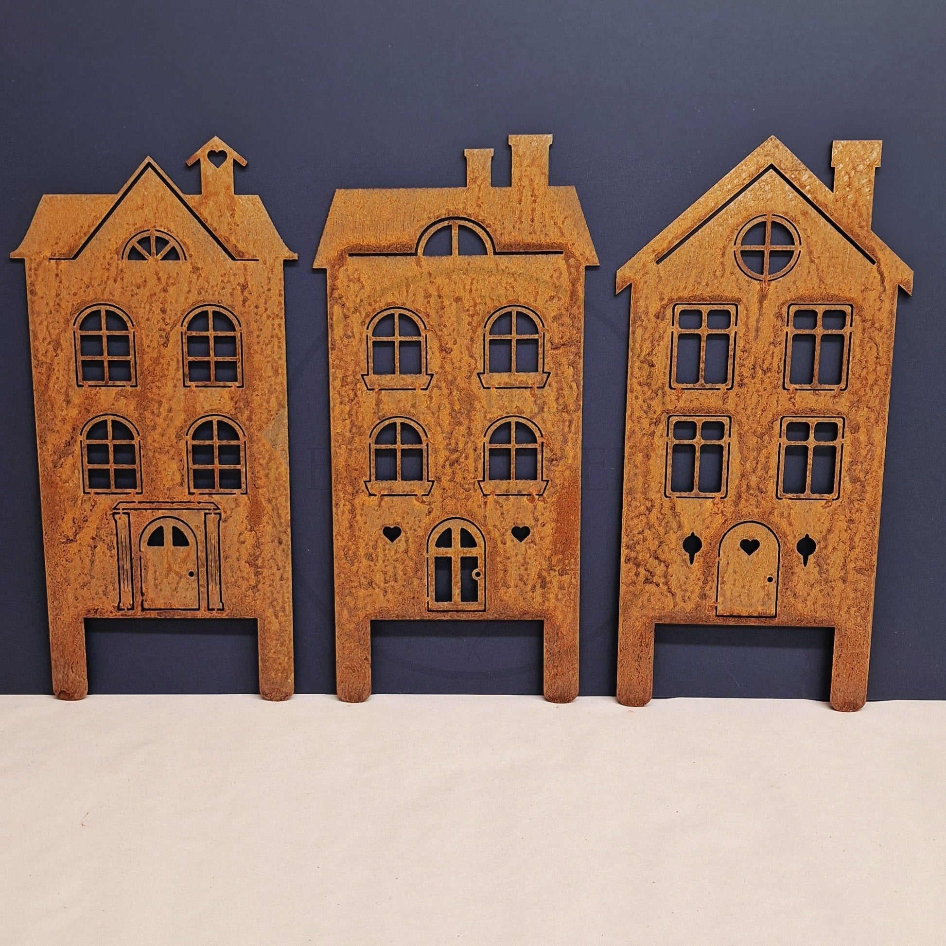 Three meetal house models against a blue background