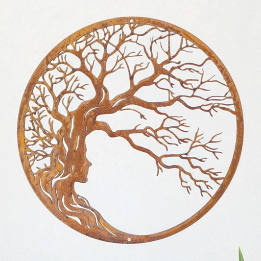 a circular metal sculpture depicting a tree with a woman's face in profile.